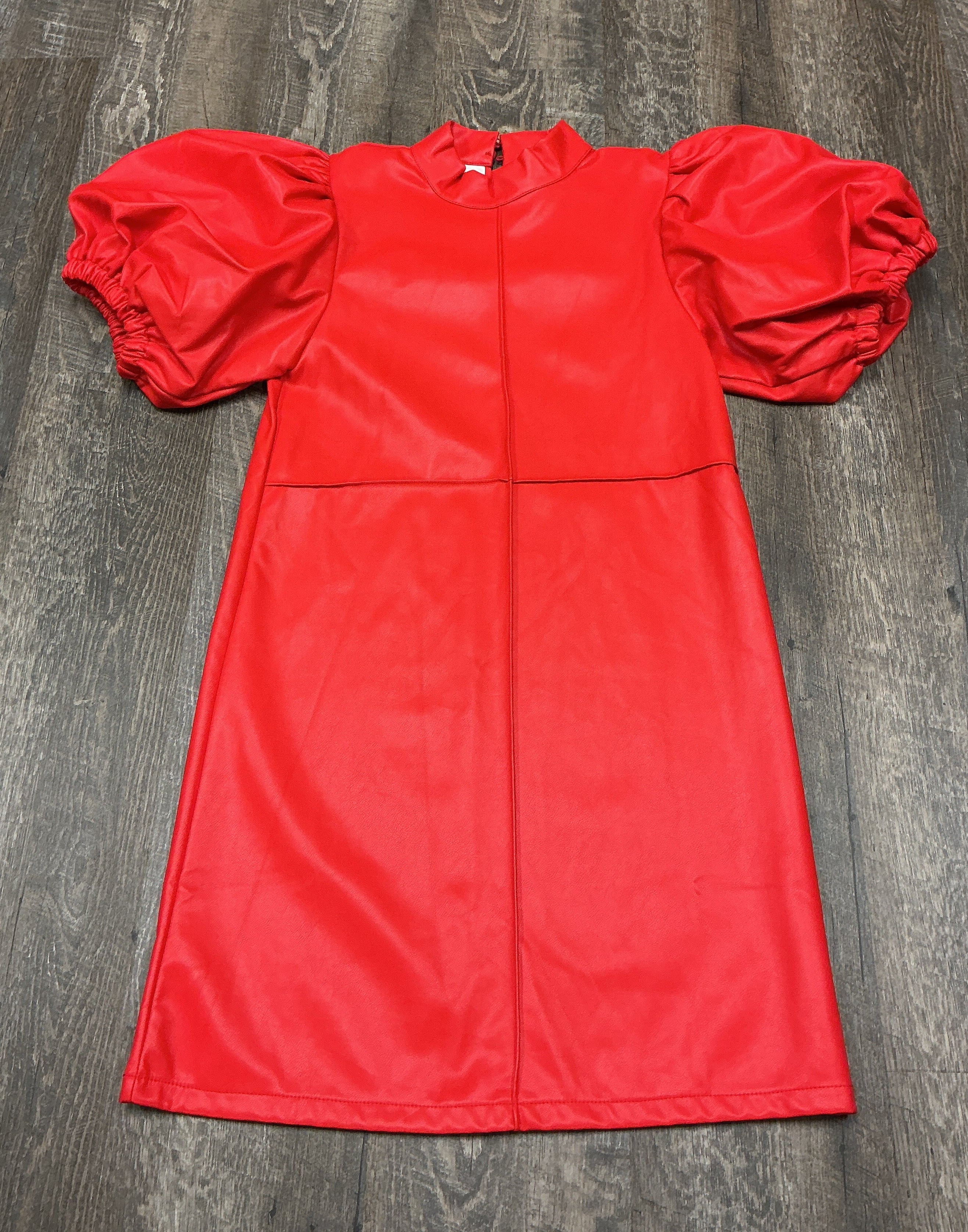 A bright red faux leather dress with puffed sleeves and a high mock neck.
